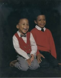 A young boy and girl smiling and sitting together in a school portrait.