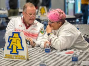 Two people discussing at a table with North Carolina A&T State University logo.