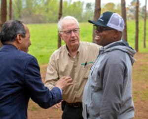 Engaged group of diverse men conversing outdoors in a park setting, promoting community and collabor.