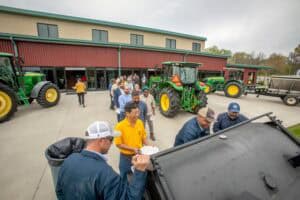 Tractor demonstration at CAES News event with farmers and agricultural experts.