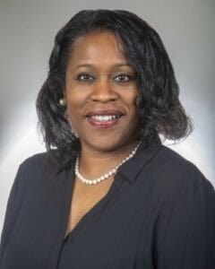 A woman smiling in professional attire, representing CAES News.