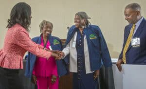 Celebration of achievement with diverse professionals shaking hands at a formal event.