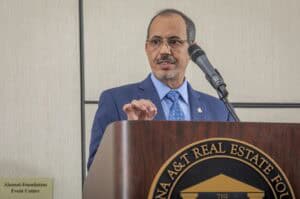 Prominent speaker at real estate conference delivering a presentation on property investment.