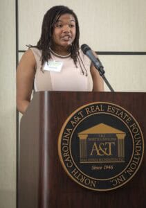 Empowered woman speaking at CAES North Carolina Real Estate Foundation event.
