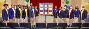Group of young professionals in formal attire presenting at a conference.
