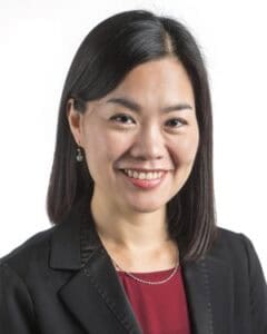 Smiling professional woman with dark hair in business suit, representing leadership and success for.