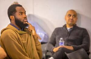Thoughtful man listening attentively during a discussion at CAES News event.