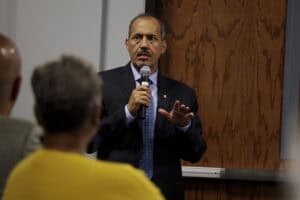 Engaged male speaker presenting at a conference or seminar on leadership and communication.