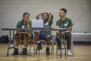 Empowered young women working together on a laptop at a community event.