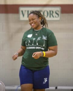 Empowered woman smiling at leadership event, promoting growth and community engagement.