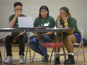 Diverse group of young people experiencing technical difficulties at a workshop.