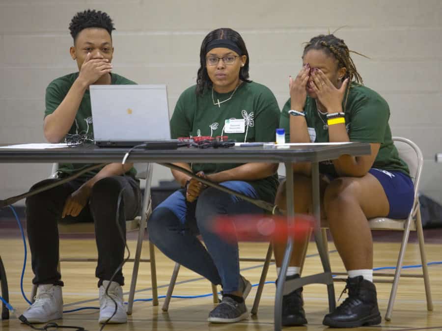 Diverse group of young people experiencing technical difficulties at a workshop.