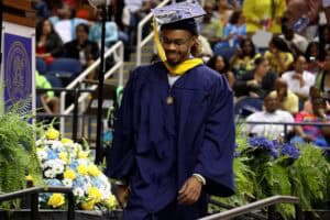 Graduation student in cap and gown at ceremony celebrating academic achievement and success.