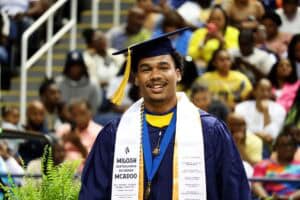 Graduation cap and gown celebration at CAES News event with diverse students.