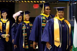 Graduates in caps and gowns at a commencement ceremony celebrating academic achievement.