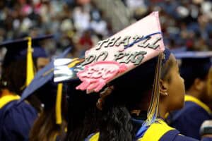 Graduation cap with "Thankful No Regret" message at a graduation ceremony.