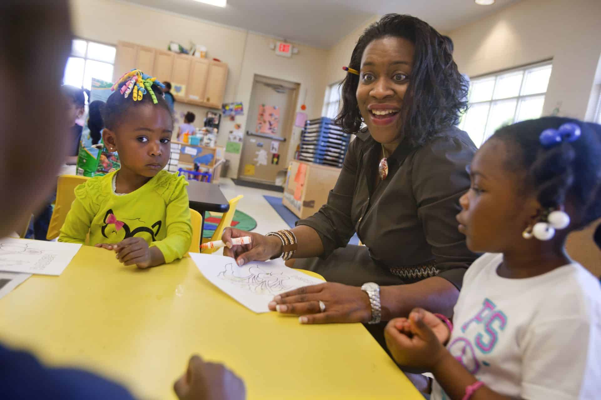 Engaging teacher interacting with young children in a classroom setting for early childhood educatio.