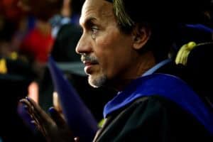 A graduate in academic regalia during a graduation ceremony.