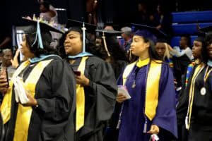 Graduates in caps and gowns at a graduation ceremony celebrating academic achievement.