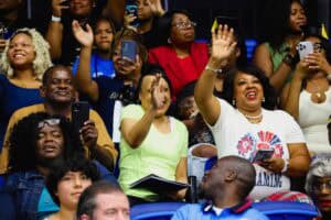 People attending a lively event, capturing moments with smartphones, smiling, and engaging actively.