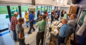 A bustling indoor event with people engaging and networking at a conference or expo.