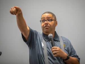 Police officer speaking passionately during a community event or training session.