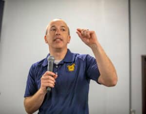 Male speaker giving a presentation at a conference or seminar.