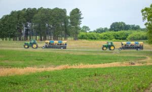Tractors with seeders working on farmland in rural landscape, agriculture machinery, farming activit.