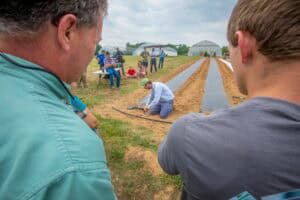 Innovative agricultural research at a farm with scientists and farmers collaborating outdoors.