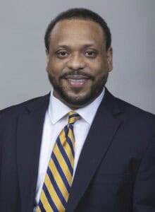 Professional African American man in suit smiling for business portrait.
