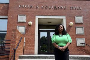 Accessible entrance at David S. Coltrane Hall with a smiling woman standing outside.