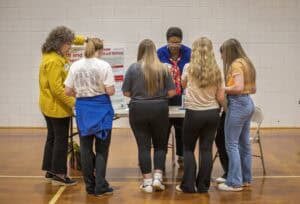 Engaged group of women at a community health and wellness event in a gymnasium.
