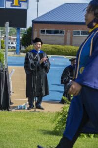 Graduation ceremony outdoors with students in caps and gowns celebrating achievement.