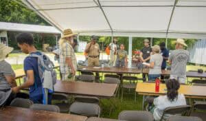 Community event with diverse group under outdoor tent setup.