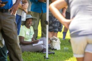 Community health worker conducting outdoor health education session with group.