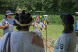 Planting community members discussing agricultural practices outdoors in a rural setting.