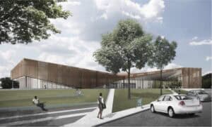 Modern architectural building with green outdoor space and parking area.