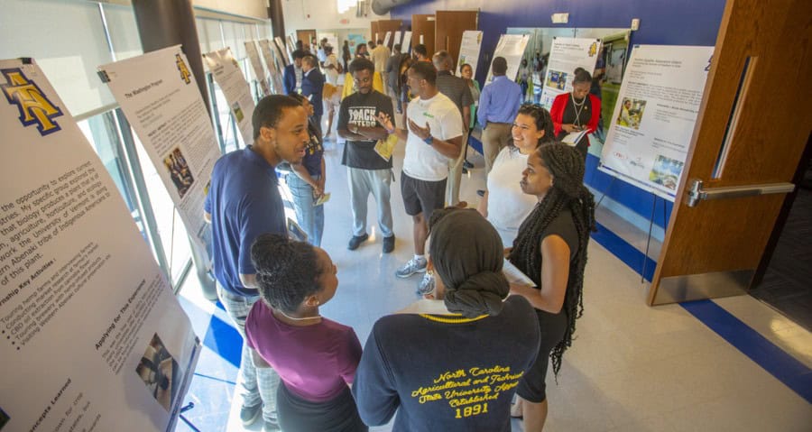 High school students presenting science projects at a school exhibition.