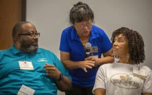 Accessible healthcare discussion at CAES News event, diverse group engaging in health awareness.
