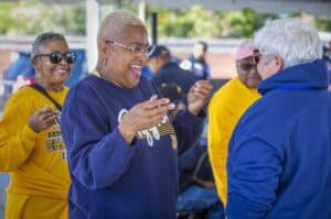 Celebrating community and sports achievements at an outdoor event with smiling, diverse seniors.