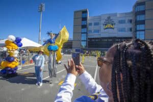 Fans taking photos outside Truest Stadium during a festive event.