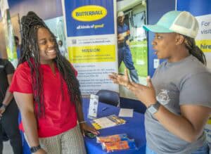 Boosted by Butterball at a career fair, two women engage in a lively conversation about job opportun.