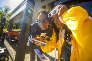 Enjoying outdoor tech activity with friends on a sunny day, capturing moments with a smartphone and.