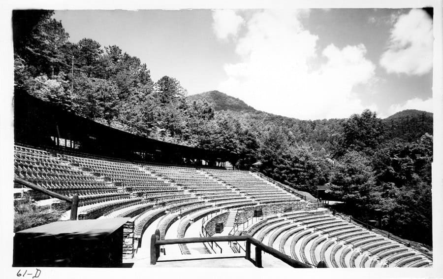 Amphitheater with tiered seating in a scenic mountain area, ideal for outdoor performances and event.