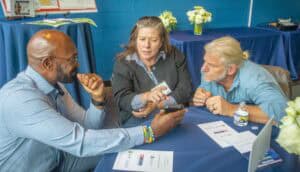 Diverse group of professionals discussing work at a conference table in a vibrant setting.
