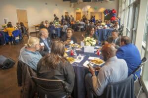 Diverse professionals networking at a corporate event in a modern conference room.