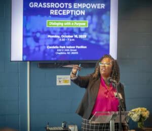Empowering community leaders at grassroots reception with speaker presenting at podium.