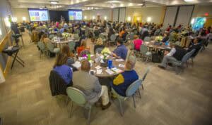 High-level conference with diverse attendees listening to presentations in a spacious, well-lit meet.