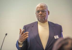 Professional man speaking at a conference or seminar in formal attire.
