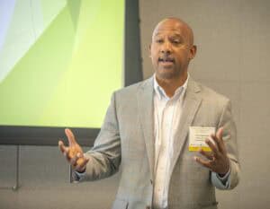 An SEO-friendly ALT tag: Business professional giving a presentation at CAES News event.
